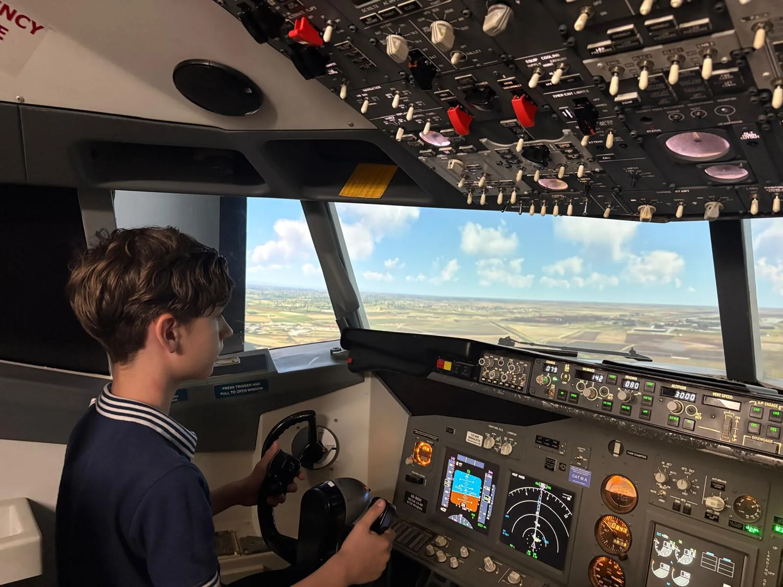 Copil în cămașă dungată la simulatorul Boeing 737