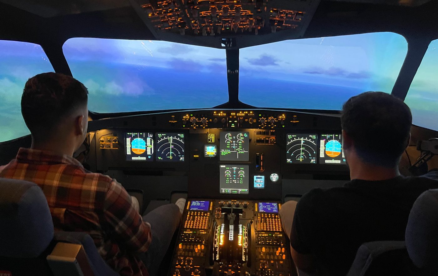 Doi piloți văzuți din spate în simulatorul Airbus A320