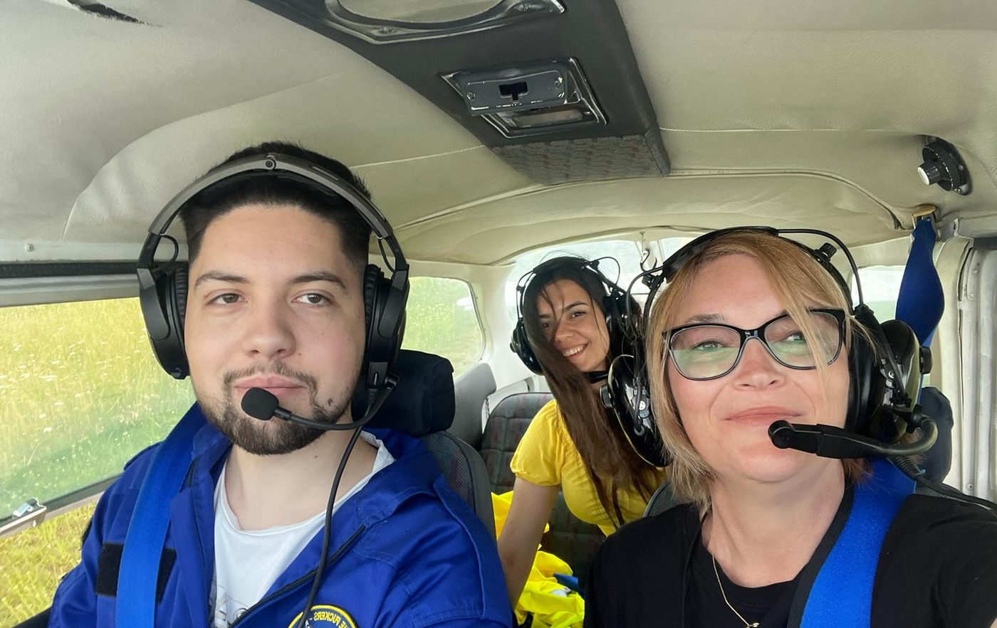 Pilot și pasageră cu căști în cabina avionului