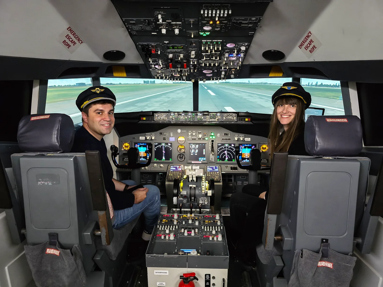 Doi participanți cu chipiu în simulatorul Boeing 737NG