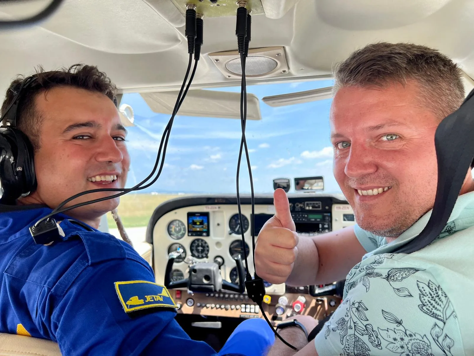 Doi bărbați cu căști în cabina unui avion ușor